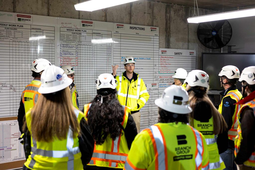 Branch Employee Group Standing In-Front of a Job Board